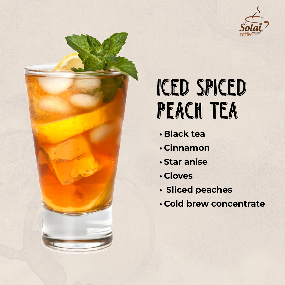 Iced Spiced Peach Tea in a glass pitcher with star anise, sliced peaches, ice cubes, and mint leaves on top.